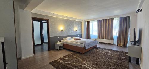 a bedroom with a bed and a large window at Conca Verde Râșnov in Râşnov