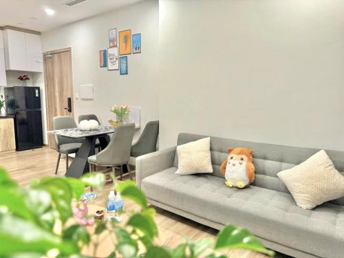 a teddy bear sitting on a couch in a living room at Ben's Homestay Ecopark - Onsen Swanlake R3 in Kim Quan
