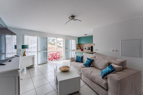 un salon avec un canapé et une cuisine dans l'établissement Appartement Alizea, à Arcachon