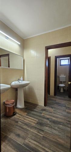 a bathroom with a sink and a toilet and a mirror at Conca Verde Râșnov in Râşnov