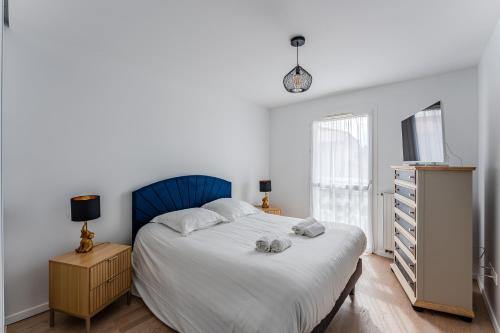 une chambre avec un lit, une commode et une fenêtre dans l'établissement Appartement Alizea, à Arcachon