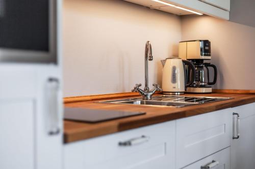 a kitchen counter with a sink and a coffee maker at App Lolita in Kühlungsborn