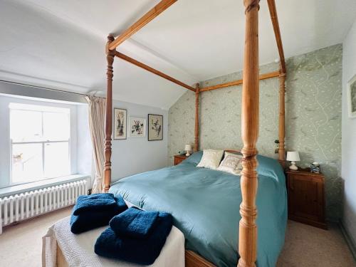 1 dormitorio con cama con dosel y ventana en Exceptional retreat near Cornwall Coast, en Tywardreath