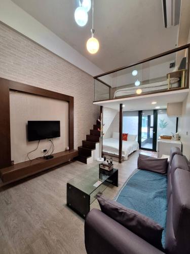 ein Wohnzimmer mit Sofa und Fernseher in der Unterkunft Love溫泉湯宿 in Jiaoxi