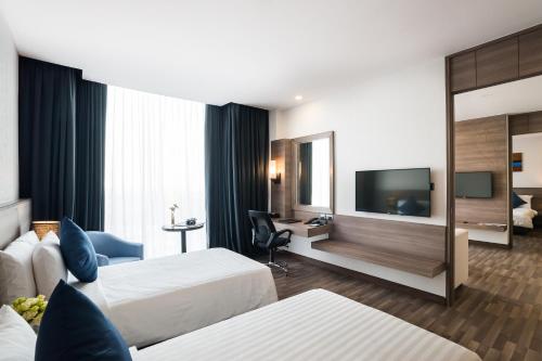 a hotel room with two beds and a flat screen tv at Best Western Plus Wanda Grand Hotel in Nonthaburi