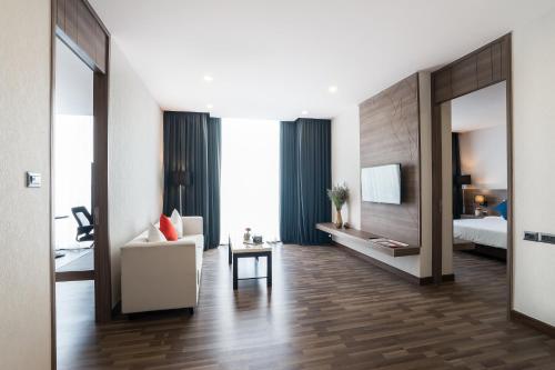 a hotel room with a bed and a living room at Best Western Plus Wanda Grand Hotel in Nonthaburi