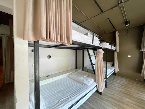 a bedroom with three bunk beds in a room at Collection O The Spades Hostel in Bangkok