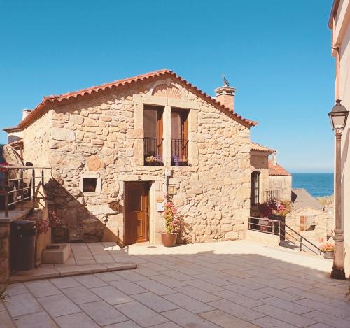 a stone building with the ocean in the background at Teresa Caeiro in Oia
