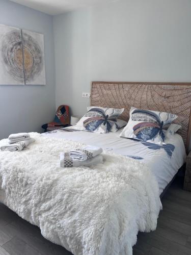 - une chambre avec 2 lits avec une couette et des oreillers blancs dans l'établissement Tout le charme de La Baule-Les -Pins T3 73m2, à La Baule