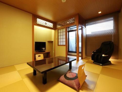a living room with a table and a chair at Arima Royal Hotel in Kobe