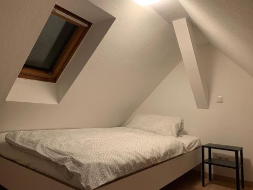 凯撒斯劳滕Monteurapartment in Kaiserslautern的窗户客房内的小床