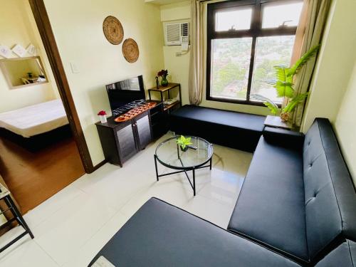 a living room with a couch and a table at Azalea 1BR Suite - Pool, Gym, WiFi, Netflix, AC, Kitchen, Ayala Mall in Cebu City