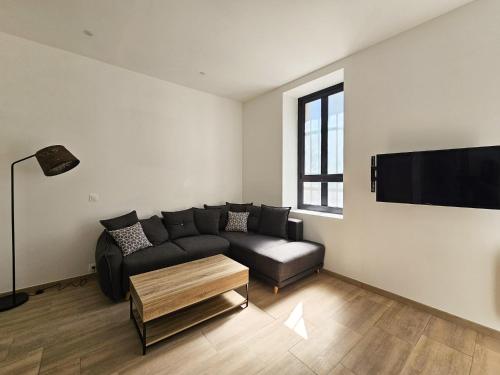 un salon avec un canapé et une télévision à écran plat dans l'établissement Joli studio rénové en centre-ville proche tramway, à Nice