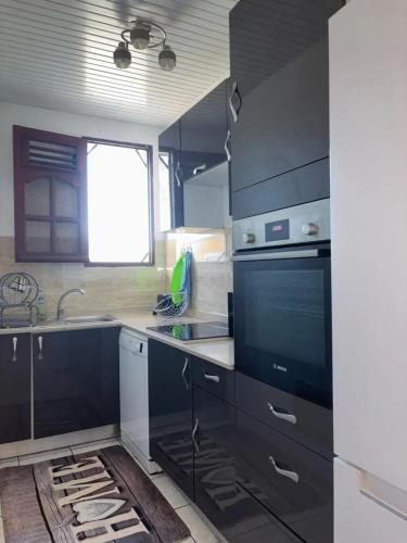 a kitchen with black cabinets and a sink at Villa moderne avec piscine privée à Le François, 70 m² in Le François