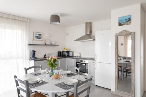 une cuisine et une salle à manger avec une table et des chaises dans l'établissement La Cabine du Val - A proximité de la Plage, à Pléneuf-Val-André