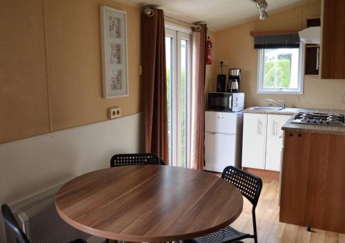 a kitchen with a wooden table and chairs in a room at Vakantiepark de Oude Molen in Groesbeek