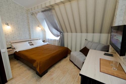 a hotel room with a bed and a couch at Hotel Hizhina in Petropavlovsk