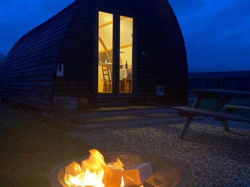 a log cabin with a fire in front of it at Millside by Wigwam Holidays in Grantham