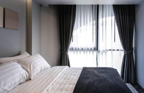 a bedroom with a bed and a large window at Collection O The Spades Hostel in Bangkok