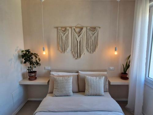 a bedroom with a bed with pillows and a window at Stazione Rooms in Quarto dʼAltino