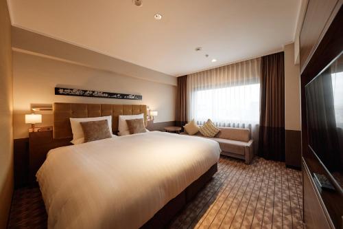 a hotel room with a large bed and a couch at Kyoto Century Hotel in Kyoto