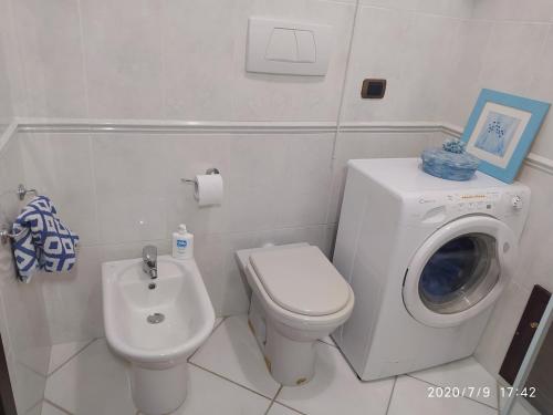 a bathroom with a washing machine and a toilet at Alice e il mare in Alghero
