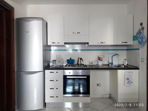 a kitchen with a stainless steel refrigerator and an oven at Alice e il mare in Alghero