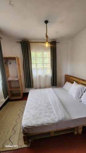 a bedroom with a large bed and a window at Mardai Homestay in Arusha