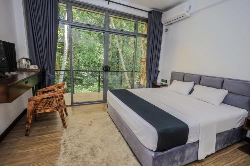 a bedroom with a bed and a large window at Forest Face Lodge in Gurudeniya