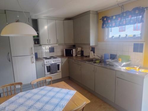 Una cocina con una mesa y un refrigerador blanco. en Äng, en Strömstad