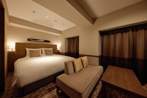 a hotel room with a bed and a chair at Kyoto Century Hotel in Kyoto