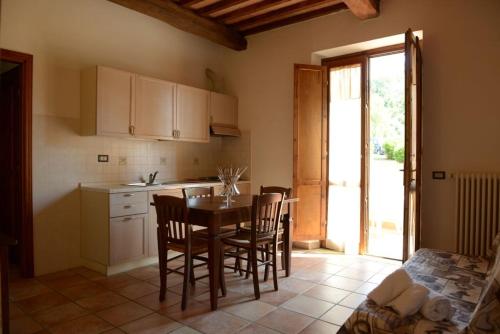 a kitchen with a table and chairs in a room at Borgo San Martino - Residence Hotel & SPA in Riparbella