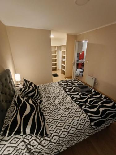 a large bed in a room with a zebra print blanket at APART CENTRO CHILLAN - DEPARTAMENTOS 2 Habitaciones in Chillán