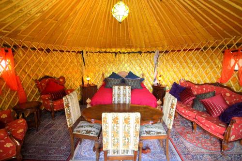 een kamer met een tafel en stoelen in een yurt bij JURTE - Traumhafter Meerblick, beheizter Pool, Sauna, Billiard, Tischtennis, Garten in La Asomada