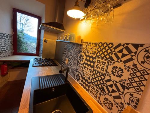 - une cuisine avec évier et quelques carreaux sur le mur dans l'établissement Le salagou sauna, à Lacoste
