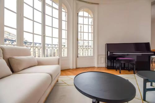 - un salon avec un canapé et un piano dans l'établissement TBS 324 - Superb apartment with Eiffel Tower view, à Paris