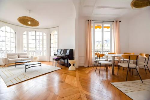 un salon avec une table et des chaises dans l'établissement TBS 324 - Superb apartment with Eiffel Tower view, à Paris