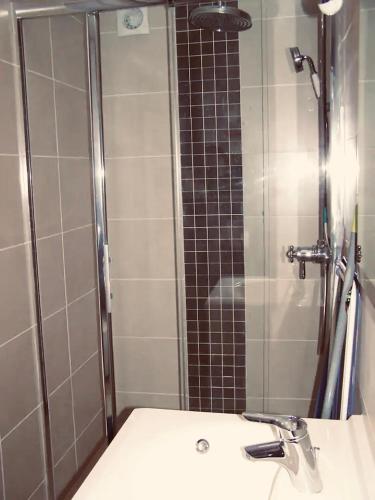 une salle de bain avec un lavabo et une douche avec un miroir dans l'établissement T2 proche plage et commerces, à Saint-Malo