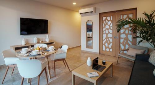 a living room with a table and a dining room at abba Suites Playa del Carmen in Playa del Carmen
