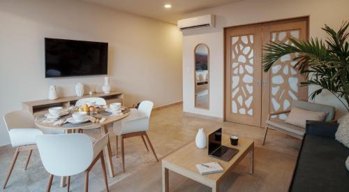 a living room with a table and a dining room at abba Suites Playa del Carmen in Playa del Carmen