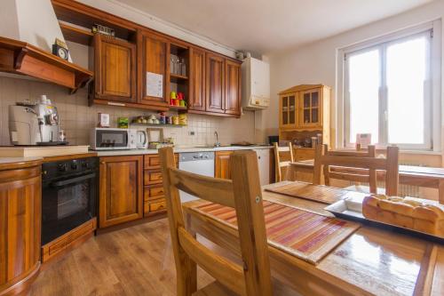 a kitchen with wooden cabinets and a wooden table with a dining room at Bed & Breakfast Al Nettuno in Trento