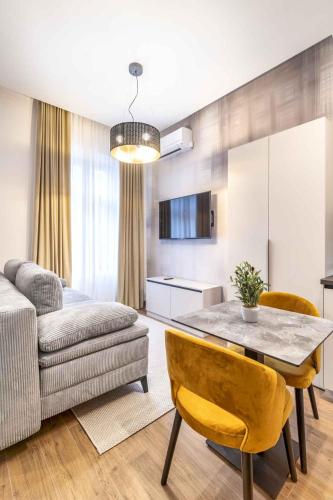 a kitchen and living room with a table and a couch at ZAGABRIA - Modern Boutique Studios by Main Square in Zagreb
