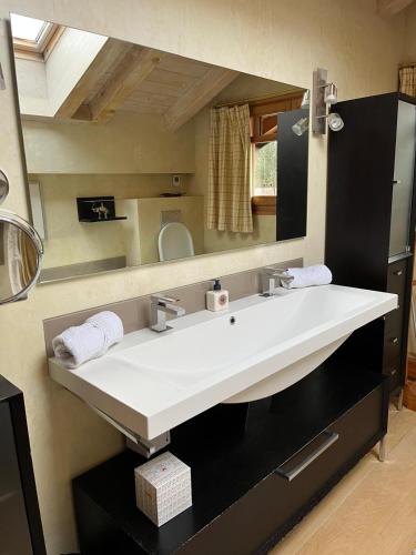 une salle de bain avec un lavabo blanc et un miroir dans l'établissement Chalet Blaise Chamonix Mont Blanc Valley, aux Houches