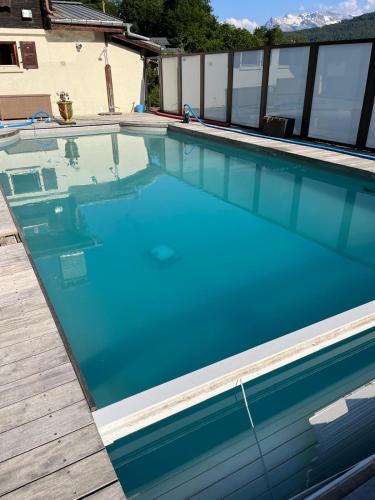 une piscine avec de l'eau bleue dans une maison dans l'établissement Chalet Blaise Chamonix Mont Blanc Valley, aux Houches