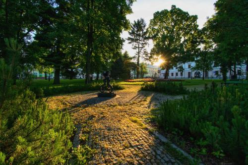 a path in a park with trees and a building at Apartament Suwałki Centrum Wesoła in Suwałki