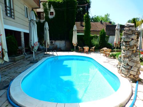 una piscina en un patio con sombrillas en Vila Senjak, en Belgrado