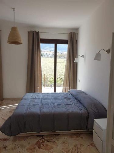 a bedroom with a bed and a large window at Al Bosco Ficuzza in Ficuzza