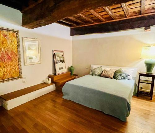 ピストイアにあるDuomo luxury loft Pistoiaのベッドと木の床のある寝室