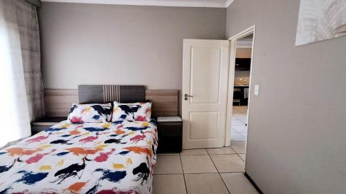 a bedroom with a bed with a comforter and pillows at Stone's Palace in Edenvale