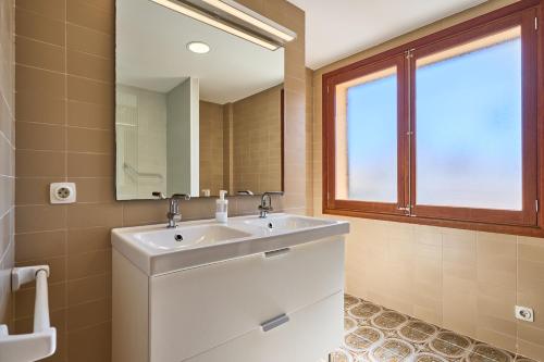 a bathroom with a white sink and a mirror at Villa Mesquida in Portocolom